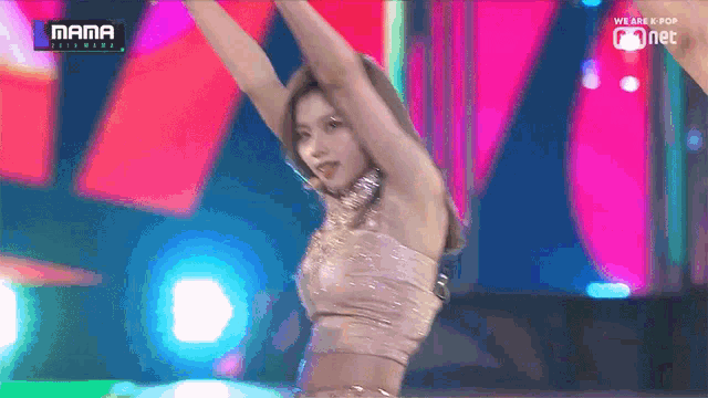 a woman is dancing on a stage in front of a screen that says mama on it