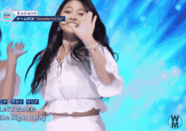 a woman in a white top and white skirt is dancing on a stage with the words let 's dance the night away behind her