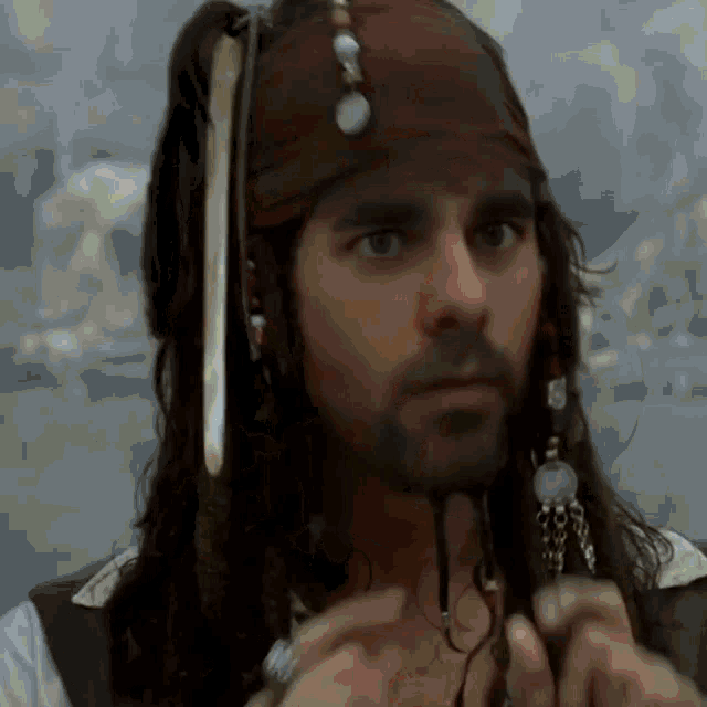a man with dreadlocks and a beard is wearing a bandana