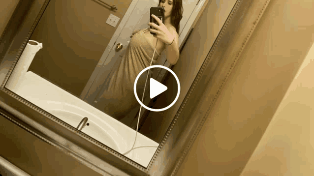 a woman taking a selfie in front of a mirror