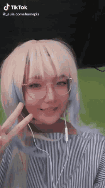 a girl wearing a wig and glasses is giving a peace sign