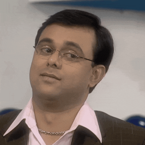 a man wearing glasses and a pink shirt is looking at the camera