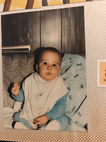 a baby is sitting on a couch with a sticker that says s on it