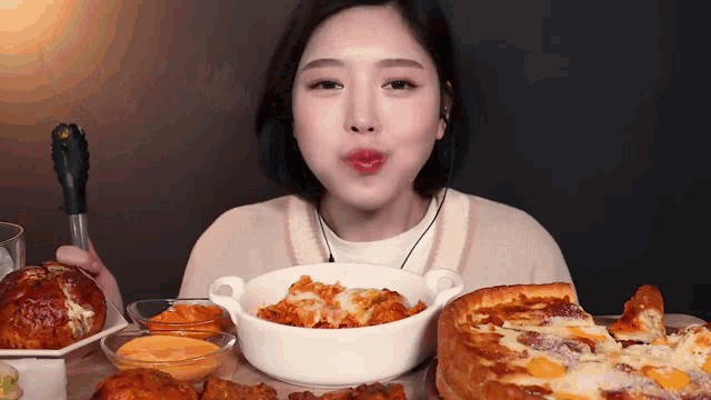 a woman is sitting at a table eating a pizza