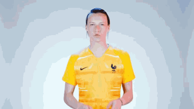 a woman in a yellow nike shirt is making a gesture