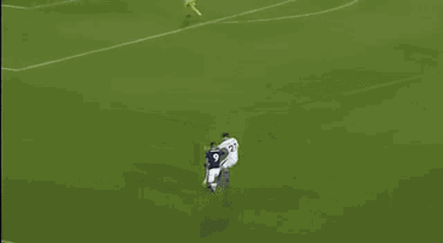 a soccer game is being played on a field with palm advertisements