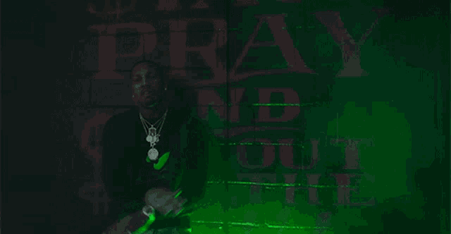 a man is standing in front of a wall that says pray and out thee