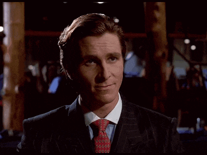 a man in a suit and tie is standing in a dark room looking at the camera .