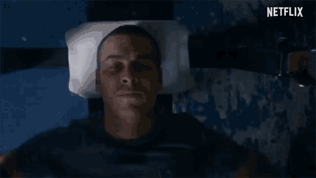 a man is laying down with his head on a pillow with netflix written on the bottom right