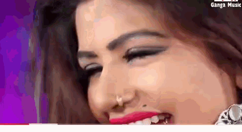 a close up of a woman 's face with a nose ring and red lips