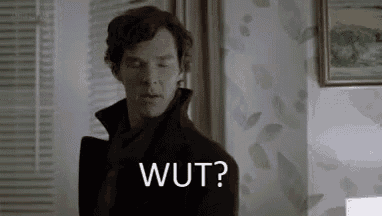 a man in a black coat is standing in a room with his eyes closed and saying wut ?