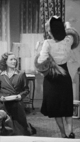 a black and white photo of two women standing in a room