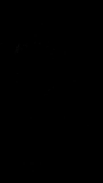 a person is standing in the dark in front of a street light .