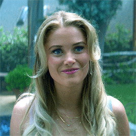 a woman with long blonde hair and blue eyes is smiling