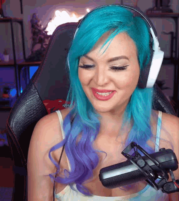 a woman with blue and purple hair wearing headphones and a microphone