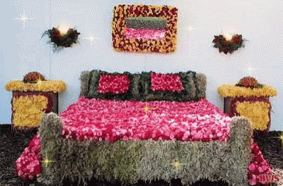 a bedroom with a bed made of flowers and a picture on the wall that says love