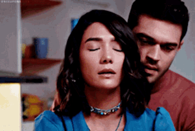 a man and a woman are hugging each other in a kitchen .