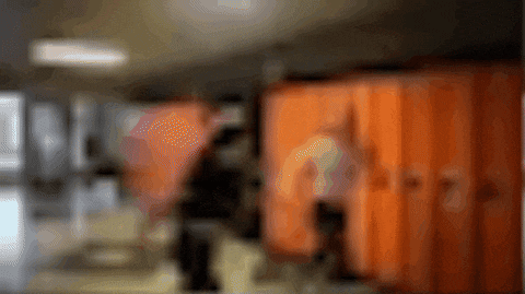 a blurry picture of orange lockers in a school hallway