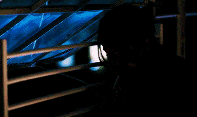 a woman is smoking a cigarette behind bars