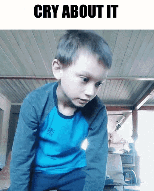 a young boy in a blue shirt with the words cry about it on the bottom