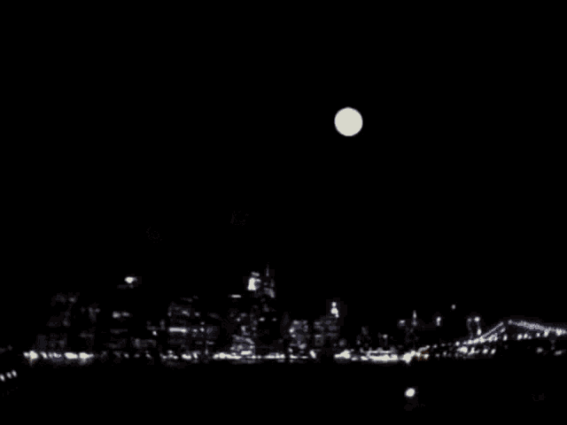 a full moon against a black sky with a few spots of light