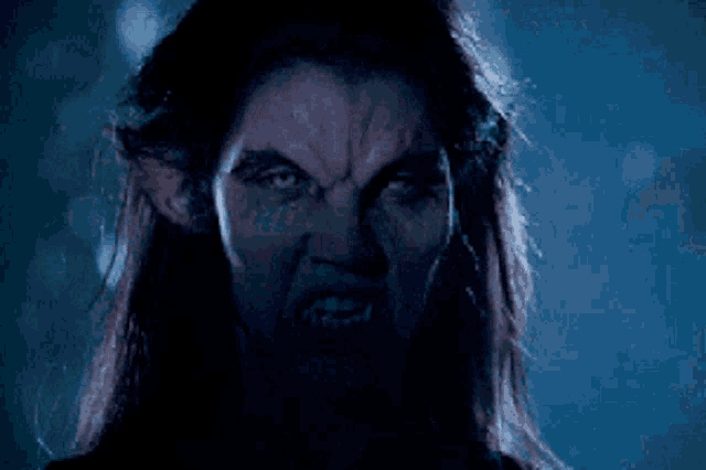 a close up of a werewolf with its mouth open and teeth showing
