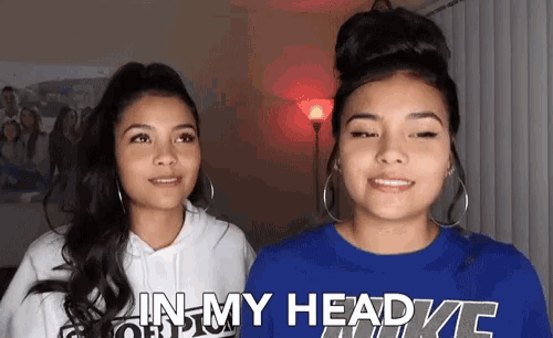 two women are standing next to each other and one of them is wearing a blue shirt that says in my head