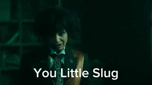 a woman in a suit and tie with the words you little slug below her
