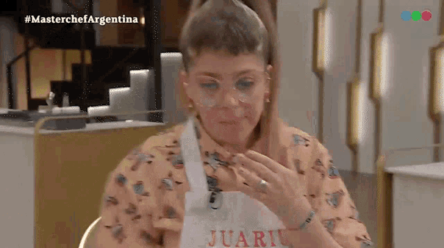 a woman wearing glasses and an apron that says juan on it