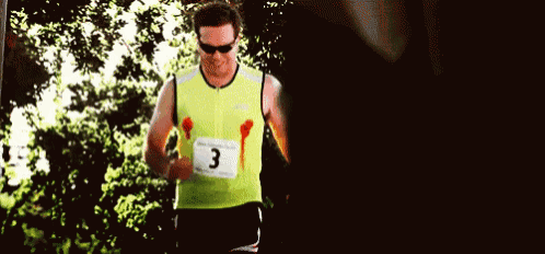 a man wearing a yellow vest with the number 3 on it is running a race