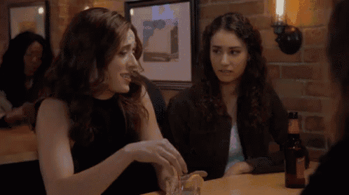 two women are sitting at a table in a restaurant talking to each other