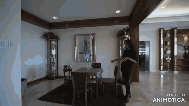 a woman stands in a dining room with the words made in animatica on the bottom