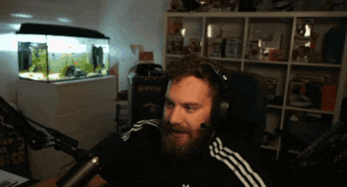 a man with a beard is wearing headphones and an adidas shirt