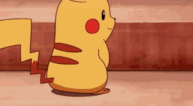 a pikachu and a pokemon are standing next to each other on a red surface .
