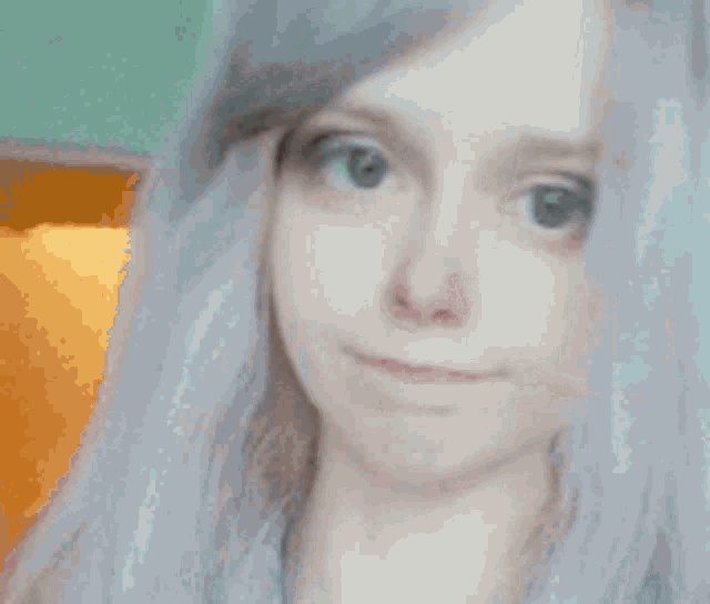 a close up of a woman 's face with a slight smile on her face