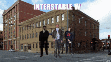 three men are standing in front of a building with the words interstable w on it