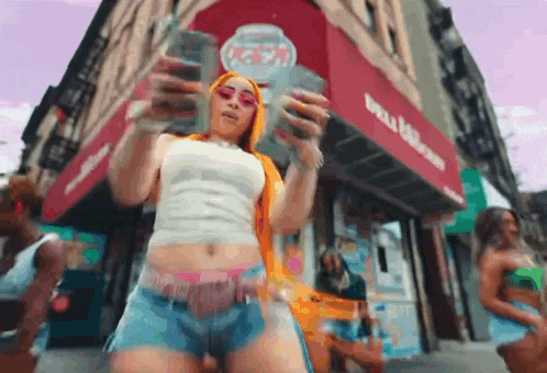 a woman is holding a bunch of money in front of a building