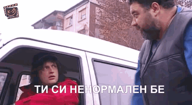 a man in a red jacket is talking to another man in a van