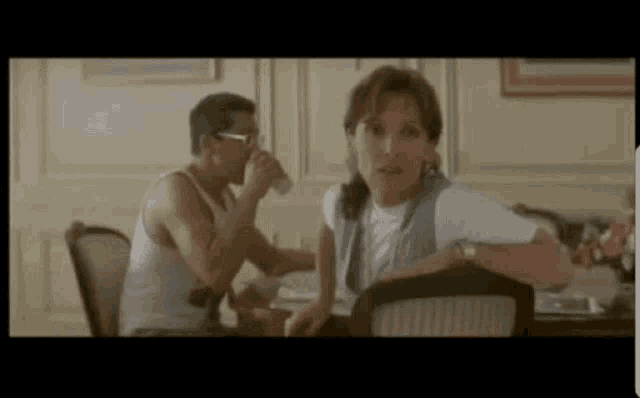 a man and a woman are sitting at a table in a room