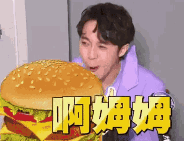 a man in a purple shirt is eating a hamburger