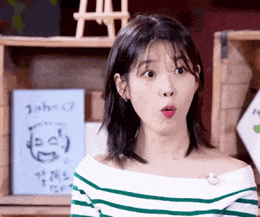 a woman making a funny face in front of a sign that says john on it