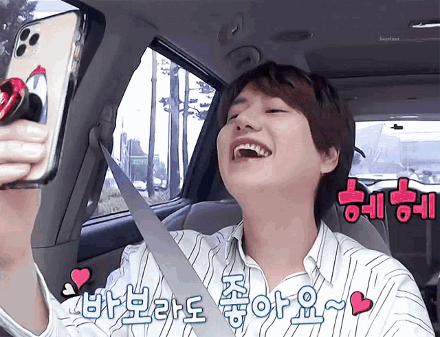 a man in a car is laughing and holding a phone