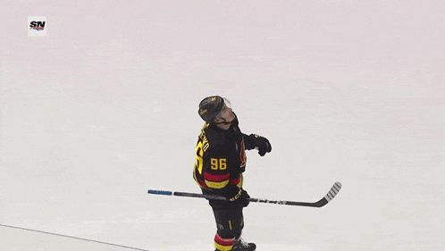 a hockey player with the number 96 on his jersey is kicking the puck