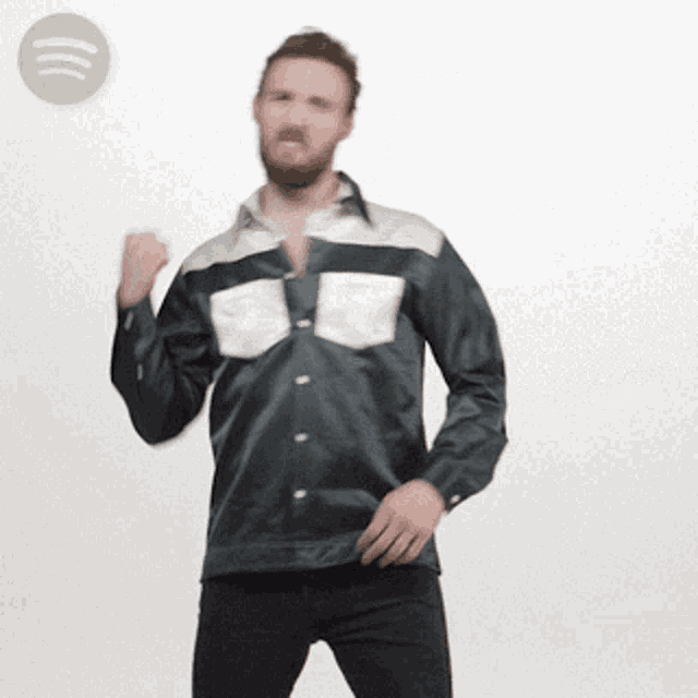 a man in a black and white shirt is dancing