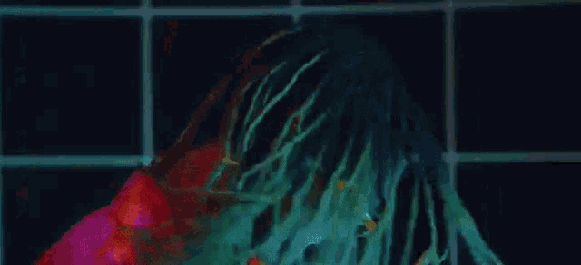 a close up of a person 's face with dreadlocks and glow in the dark paint .