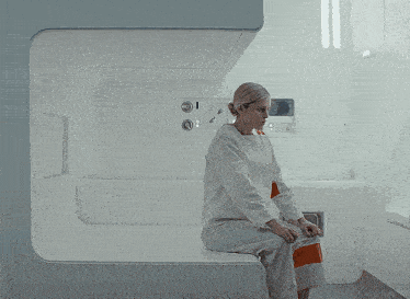 a woman sits on a couch in a room with the word keg on the bottom left