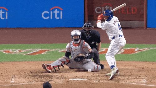 a baseball player with the number 4 on his jersey swings at a ball