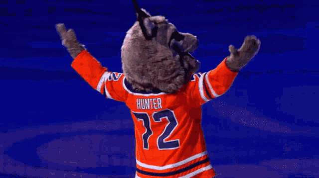 a mascot for the edmonton oilers is standing on a blue background