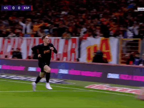 a soccer player is running on the field with a sign that says gs on it