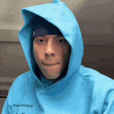 a man wearing a blue hoodie that says chrome hearts on it